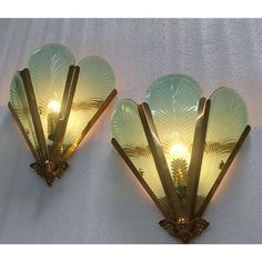 two wall sconces with glass shades on them