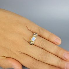 This is a unique and one off engagement ring. The band is made of 14K solid gold with a beautiful setting of small lab opal gemstones. At the center, you will find a genuine faceted peridot set in 22K solid gold bezel welded on 14k solid gold. The solid gold is also hammered around the peridot gemstone and makes this ring a truly unique and delightful organic piece. Embellished with solid gold balls for a special look. This ring can be worn as an engagement ring or just for you to feel special. Gold Moonstone Ring With Accent Stones For Promise, Gold Opal Ring With Accent Stones For Anniversary, Gold Moonstone Ring With Accent Stones Fine Jewelry, Gold Opal Ring With Rose Cut Diamonds For Promise, Gold Opal Ring With Diamond Accent Stones, Gold Moonstone Ring With Center Stone, Gold Moonstone Promise Ring With Center Stone, Gold Opal Ring With Rose Cut Diamonds For Anniversary, Anniversary Gold Opal Ring With Rose Cut Diamonds