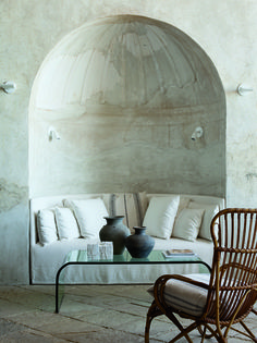 a living room filled with furniture next to a stone wall