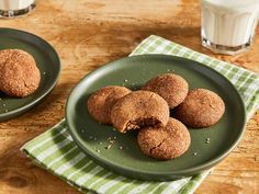 some cookies are on a green plate next to a glass of milk