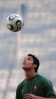 a soccer player is reaching up to catch the ball in mid air with his head