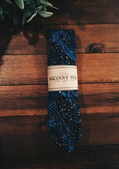 a blue tie sitting on top of a wooden floor next to a potted plant