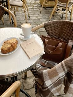 a table with a plate of food and a cup of coffee sitting on top of it