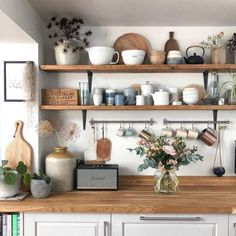 a kitchen with shelves filled with pots, pans and other items on top of it