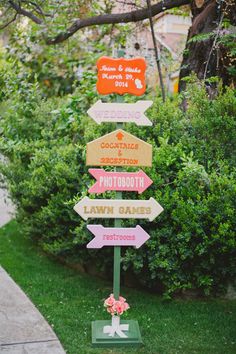 a wooden sign with many different signs on it's side in front of some bushes