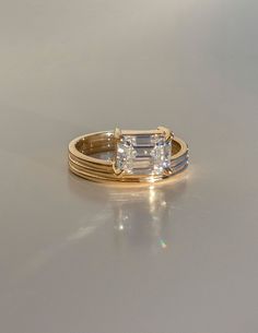 an engagement ring with two bands and a baguette cut diamond