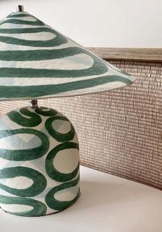 a green and white lamp sitting on top of a table