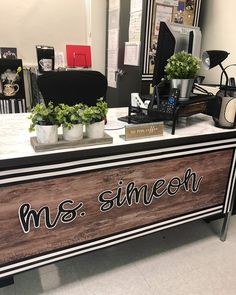 an office desk with plants and pictures on the wall behind it that says ms shineon