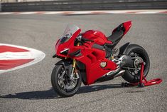 a red motorcycle parked on top of a race track