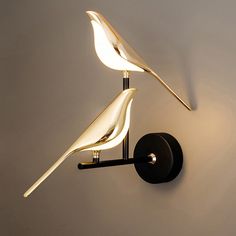 a wall mounted light with two birds on it