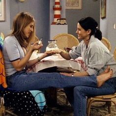 two women sitting at a table talking to each other