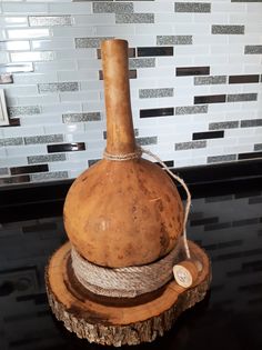 a large wooden bottle sitting on top of a table next to a tile backsplash