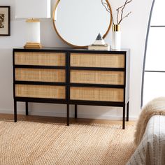 a bedroom with a rattan dresser and round mirror