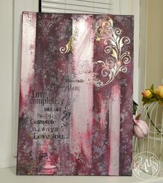 a painting with words on it sitting next to a vase filled with flowers and tulips