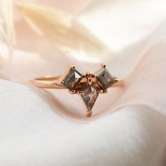 three stone ring sitting on top of a white cloth