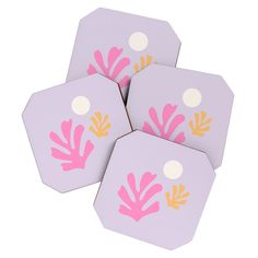 four pink and yellow coasters with white dots on the top one has an image of leaves