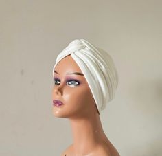 "Handmade ivory white colour front twist vintage style twist turban . This turban is a simple yet stylish cap made out of a light weight and soft feel stretchy fabric.  This is perfect to be worn with hair up or down, indoors or outdoors, social and religious gatherings.  It's made in two layers therefore can provide warmth for your head and ears in cold weather while still remaining stylish.  This can serve as a gift to a loved one, wife, mum, sister, daughter or friend. It's a go to cap for wo Elegant White Headwrap Headband, Elegant White Headband Headwrap, Elegant White Headwrap One Size Fits Most, White Summer Turban, Fitted White Headwrap For Summer, White Fitted Headwrap For Summer, White One Size Headscarf, Elegant Fitted White Turban, Elegant White Fitted Turban