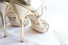 a pair of high heeled shoes sitting on top of a white cloth covered table