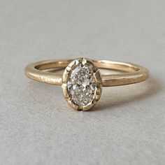 a close up of a ring with a diamond in the center on a white surface