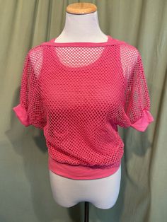 This is a fun vintage top from the 70s or 80s.  Labeled has been snipped out. The bust measures 25" to 34", see measurements below. This fun top has the look of 2 layered tops but is all in one. It is a pink cotton blend strappy, sleeveless tank top bottom layer with a mesh short sleeve top layer. The two layers are attached at the band bottom. The tank part is a soft ribbed tank. The mesh is an open weave with dolman sleeves. The sleeves have knit cuff bands, as does the neckline.    The top is in very good condition!  No damage or soil. Super cute!  If you have never worn vintage before, please measure yourself!! Vintage sizes run smaller than today's sizes, know your measurements before buying! Bust measured from side seam to side seam at the underarm: stretches from 12.5" to 17" for a Pink 90s Style Spring Tops, Pink Retro Stretch Top, Pink Stretch Retro Top, Spring Vintage Crew Neck Crop Top, Vintage Crew Neck Crop Top For Spring, Retro Stretch Pink Top, Vintage Stretch Summer Tops, Vintage Stretch Tops For Summer, 90s Style Stretch Tops For Spring