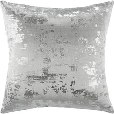 a silver velvet pillow with white and grey paint on it's edges, in front of a white background