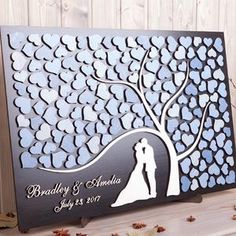 a wedding card with the silhouette of a couple under a tree and hearts on it