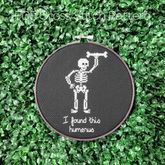 This hilarious cross stitch shows a cheeky skeleton holding up a large bone with the words "I found this humerus" in cursive backstitch below. A great gift for a lover of puns or anyone with "dad humor"! This one is super fast and easy to stitch up and can easily be completed in 1 or 2 days! Shown in the listing photo as stitched on 14 count black aida and framed in a 6 inch hoop. The stitched image is 41w x 74h stitches. This pattern uses full and back stitches only. This listing is for the pattern only. No physical item will be sent. 2 PDF patterns are included in this listing.  One PDF will include:  * a cover page with a digital mockup of the pattern * black and white symbols on grid * DMC floss legend * color blocks with symbols on grid (symbols will be black unless the floss color is Skeleton Cross Stitch Pattern, Skeleton Cross Stitch, Gift Embroidery, Cute Puns, Funny Skeleton, Pun Gifts, In Cursive, Stitch Lines