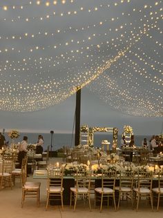 an outdoor wedding reception setup with string lights