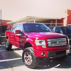 a red pickup truck parked in a parking lot