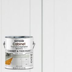 a can of white paint sitting on top of a wooden floor next to a wall