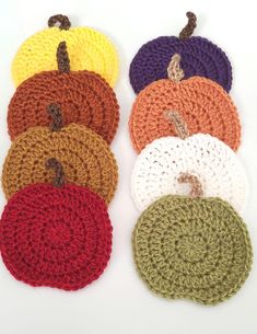 several crocheted pumpkins are arranged in rows