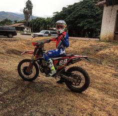 a person on a dirt bike in front of some cars