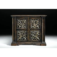 an ornate wooden cabinet with four doors and carvings on the front, in dark wood