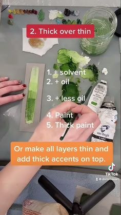 a woman is cutting broccoli on a table with scissors and other things around her