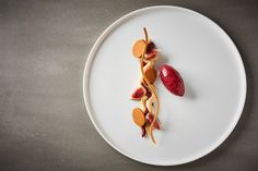 a white plate topped with food on top of a gray table next to a knife and fork