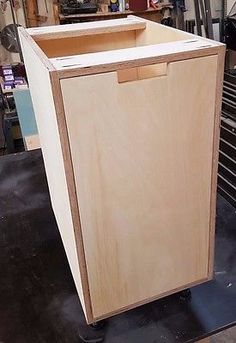 a wooden cabinet sitting on top of a metal rack in a garage next to other tools