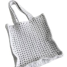 a white crocheted bag is shown on a white background with the handles down