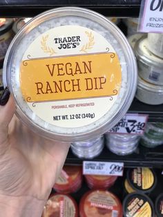 a hand holding a jar of vegan ranch dip