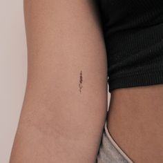 a woman's arm with a tiny tattoo on the left side of her arm