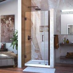 a bathroom with a walk in shower next to a bed