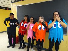 five children in costumes standing next to a blackboard with googly eyes on it