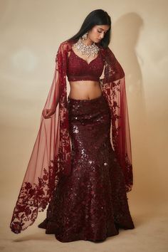 Burgundy mermaid lehenga with an attached cancan and sequins hand embroidery. Comes with a padded blouse and a floral work dupatta.
Components: 3
Pattern: Hand embroidered
Type Of Work: Sequins, Floral
Neckline: Leaf Neck
Sleeve Type: Sleeveless
Fabric: Tulle, Sequins georgette, Buttercrepe
Color: Maroon
Other Details: 
Heavily embroidered blouse
Lehenga length : 45 inches
Occasion: Destination Wedding - Aza Fashions Fitted Net Pre-draped Saree For Reception, Glamorous Organza Sharara For Diwali, Fitted Bollywood Net Gown, Wedding Fitted Net Sharara, Glamorous Designer Lehenga With Pallu, Glamorous Net Lehenga For Wedding, Elegant Fitted Net Lehenga, Glamorous Fitted Organza Lehenga, Glamorous Wedding Sharara With Unstitched Blouse