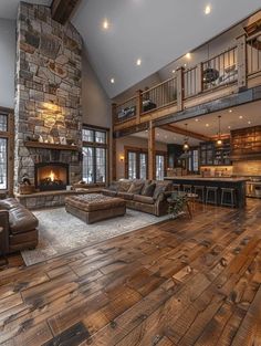 a living room filled with furniture and a fire place in the middle of a wooden floor