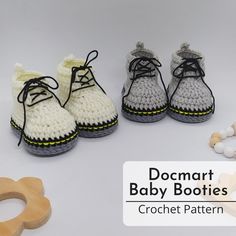 crocheted baby booties, pacifier and teethpictches on a white background