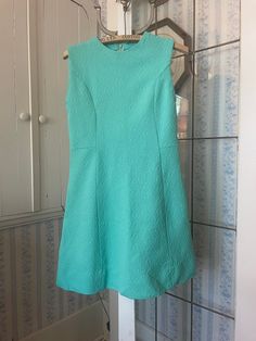 This simple dress is made from medium weight polyester in medium green, with an allover raised pattern (see photo for pattern, not colour). It fastens with a long zipper in the back. The measurements, taken with the dress lying flat, are: shoulder to shoulder, 14 inches; armpit to armpit, 16 inches; waist, 16 inches; length, 31 inches; bottom edge, 22 inches. In very good condition. Green Sleeveless Dress, Green Knit Dress, Vintage Green Dress, Simple Dress, Dress Sleeveless, Dress Short, Dress Clothes For Women, Simple Dresses, Short Dress