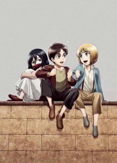 three people sitting on top of a brick wall