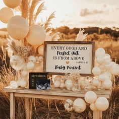 a table with balloons and a sign that says every good and perfect gift is from above