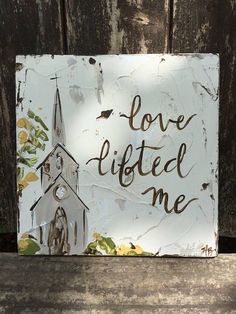 a sign that says love lifted me with a church in the background and leaves on it