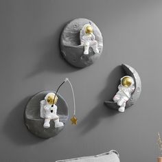 three wall clocks with an astronaut on the moon and a gold star hanging from them