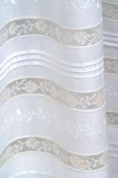 white lace curtains are lined up in rows